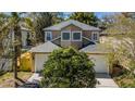 This is an eye-level exterior view that highlights a two-car garage and neatly landscaped front yard at 409 S Arrawana Ave, Tampa, FL 33609