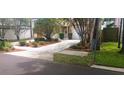 Well-maintained front yard featuring lush greenery, mulch beds, and a spacious driveway leading to a two-car garage at 409 S Arrawana Ave, Tampa, FL 33609
