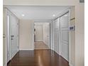 Bright foyer with dark hardwood flooring, a coat closet, and entrance into the carpeted living area at 4160 Pinelake Ln # 201, Tampa, FL 33618