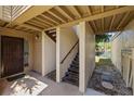 Exterior entrance with open staircase, tan stucco walls, and walkway to a waterway at 4160 Pinelake Ln # 201, Tampa, FL 33618