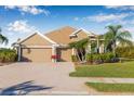 Inviting single-story home with a three-car garage, brick driveway, and neatly manicured landscaping at 4315 70Th E Ave, Ellenton, FL 34222