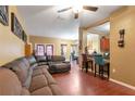 Spacious living room featuring hard wood floors, comfortable seating, and a bar overlooking the kitchen at 5831 Leopardstown Dr, Tampa, FL 33610