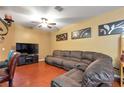 Comfortable living room with a ceiling fan, entertainment center, and a large sectional sofa at 5831 Leopardstown Dr, Tampa, FL 33610