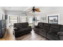 Bright living room featuring wood floors, comfortable seating, and many windows at 647 Yawl Ln, Palm Harbor, FL 34683