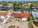 Waterfront home with dock, boat lift, circular driveway, and mature landscaping in a coastal community at 727 Flamingo Dr, Apollo Beach, FL 33572