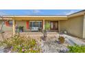 Inviting front porch with seating and double-door entry, enhanced by vibrant flowers and well-maintained landscaping at 727 Flamingo Dr, Apollo Beach, FL 33572