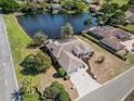 An aerial view of a single Gathering home with tile roof on a large lot with mature trees and lake views at 10084 Twelve Oaks Ct, Weeki Wachee, FL 34613