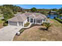 Exterior view of a single Gathering home with a tile roof, columns, and a three car garage at 10084 Twelve Oaks Ct, Weeki Wachee, FL 34613