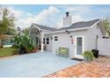 A charming single-story home with a cozy bench and a brick-paved area by the entrance at 1016 Greenleaf Way, Tarpon Springs, FL 34689