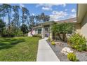 Inviting entrance with a well maintained lawn, landscaped garden and walkway leading to the front door at 1221 Dustin Rd, North Port, FL 34288