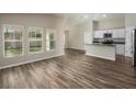 Spacious living room featuring beautiful flooring, large windows, and an open layout to the kitchen at 14777 Summer Branch Dr, Lithia, FL 33547