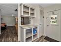 Bright entryway with white cabinetry, shelving, and durable wood-look flooring at 1608 Thrush Dr, Zephyrhills, FL 33540