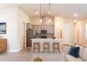 Modern kitchen with gray cabinets, stainless steel appliances, island with seating, and pendant lighting at 16265 San Edmundo Rd, Punta Gorda, FL 33955