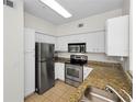 Well-lit kitchen boasts stainless steel appliances, granite countertops, and ample cabinet space at 1810 E Palm Ave # 5222, Tampa, FL 33605
