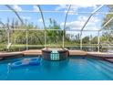 The pool and spa offer a relaxing oasis with a picturesque view of the serene backyard pond at 19826 Wyndham Lakes Dr, Odessa, FL 33556