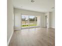 Bright living room features a sliding glass door with a view of the landscaped yard and pond at 1988 Webbstone Way, Zephyrhills, FL 33541