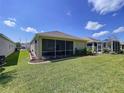 Expansive backyard featuring lush green grass, a screened lanai, and manicured landscaping at 23717 Coral Ridge Ln, Land O Lakes, FL 34639