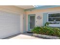 Close-up of front door entrance with beautiful flower box and updated garage door at 2593 W Vina Del Mar Blvd, St Pete Beach, FL 33706