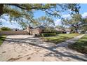 View of the yard and brick home featuring a driveway, garage and landscaped front yard at 2604 Manor Oak Dr, Valrico, FL 33596