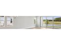 Bright, airy living room with large windows and sliding glass doors overlooking the outdoor scenery at 35587 Stableton Ln, Zephyrhills, FL 33541