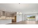 Open-concept living space with modern kitchen, dining area, and views of the outdoor scenery at 35593 Stableton Ln, Zephyrhills, FL 33541