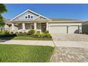 Charming single-story home with a three-car garage, covered front porch, and well-maintained lawn at 4521 Tour Trce, Land O Lakes, FL 34638