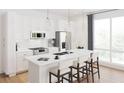 Modern kitchen with stainless steel appliances, white cabinetry, and a spacious island with bar seating at 600 3Rd S Ave # 210, St Petersburg, FL 33701