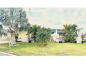 Charming single-story home with mature trees, lush lawn, and colorful potted plants for a vibrant curb appeal at 9790 66Th N St # 321, Pinellas Park, FL 33782