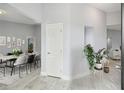 Bright hallway featuring light gray walls, stylish gray flooring, and an open dining space at 104 1St Ne Ave, Lutz, FL 33549