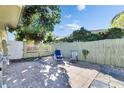 Cozy tiled back patio with lounge chairs and a privacy fence, perfect for outdoor relaxation at 10719 Drummond Rd, Tampa, FL 33615
