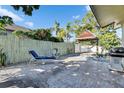 Relaxing tiled back patio featuring lounge chairs, a grill, and a shaded hammock area at 10719 Drummond Rd, Tampa, FL 33615