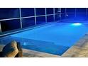 Modern in-ground pool with an inviting blue glow, perfect for an evening swim and relaxation at 15703 Jericho Dr, Odessa, FL 33556