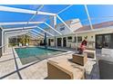 Inviting in-ground pool with screened enclosure, outdoor seating area, and bar for relaxation and entertaining at 15703 Jericho Dr, Odessa, FL 33556