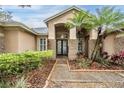 Stunning front entry with manicured landscaping, beautiful plants, and a sidewalk leading to the front door at 19223 Wind Dancer St, Lutz, FL 33558