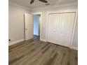 Neutral bedroom with closet and wood-look floors, freshly painted walls, and bright trim at 2022 Camelot Dr # 9, Clearwater, FL 33763