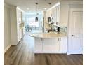 Bright, updated kitchen features modern white cabinets, stylish countertops, and wood-look flooring at 2022 Camelot Dr # 9, Clearwater, FL 33763