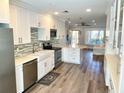 Spacious kitchen featuring white cabinets, stainless steel appliances, and an open layout to the living area at 2022 Camelot Dr # 9, Clearwater, FL 33763