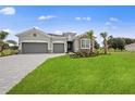 Well-maintained single-story home featuring a two-car garage, stone accents, and vibrant landscaping at 24041 Peppercorn Rd, Punta Gorda, FL 33955