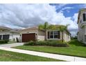 Inviting single-story home featuring a beautiful lawn and a two-car garage at 32768 Tree Of Life Ave, Wesley Chapel, FL 33543