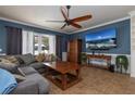Comfortable living room with a large sectional sofa, ceiling fan, and a wall-mounted TV, creating a cozy atmosphere at 4859 Augusta Ave, Oldsmar, FL 34677
