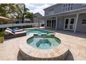 Backyard pool and spa area with a covered patio, lounge chairs, and a well-maintained lawn at 4859 Augusta Ave, Oldsmar, FL 34677