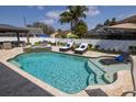 Inviting backyard pool with waterfall feature, stylish lounge chairs, and lush tropical landscaping at 4859 Augusta Ave, Oldsmar, FL 34677