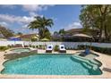 Inviting backyard pool and spa featuring lush landscaping and ample lounge space, perfect for outdoor relaxation and entertainment at 4859 Augusta Ave, Oldsmar, FL 34677