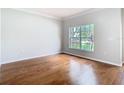Inviting living room with hardwood floors, large window offering natural light, and neutral paint throughout at 6328 Desert Peace Ave, Land O Lakes, FL 34639