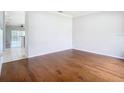 Bright living room boasts gleaming hardwood floors, fresh paint, and opens to other living areas at 6328 Desert Peace Ave, Land O Lakes, FL 34639
