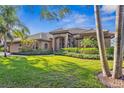 Landscaped front yard with mature trees, lush lawn, and covered entryway leading to this home at 7226 Bryce N Pt, Pinellas Park, FL 33782