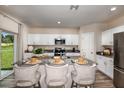 Bright eat-in kitchen features white cabinets, stainless appliances, and a backyard view at 7647 Peace Lily Ave, Wesley Chapel, FL 33545
