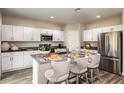 Modern kitchen with stainless steel appliances, gray countertops, and stylish barstool seating at 7647 Peace Lily Ave, Wesley Chapel, FL 33545