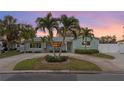 Quaint single-story home with a circular driveway, lush greenery, and a welcoming facade at dusk at 1003 39Th Ne Ave, St Petersburg, FL 33703
