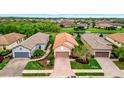 An aerial view of a well-maintained home with lush landscaping and views of a serene pond at 10213 Saint Francis Ter, Palmetto, FL 34221